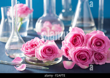 L'alchimie et l'aromathérapie avec fleurs de rose et de flacons de produits chimiques Banque D'Images