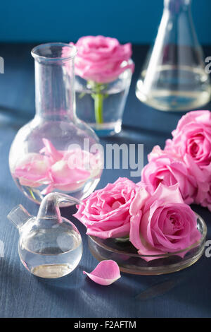 L'alchimie et l'aromathérapie avec fleurs de rose et de flacons de produits chimiques Banque D'Images