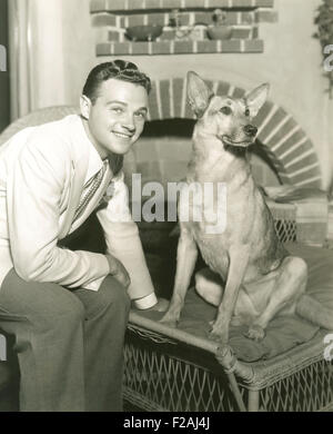 Jeune homme assis avec chien à la maison (OLVI007 OU  F845) Banque D'Images