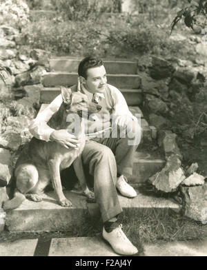 Jeune homme assis avec chien sur les mesures à l'extérieur (OLVI007 OU  F838) Banque D'Images