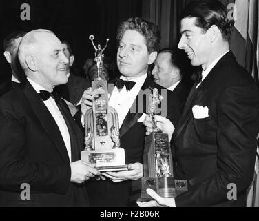 Champion de billard, Willie Hoppe, reçoit un trophée comme 'les plus de 1941 athlètes courageux." Avec la pneumonie, il est passé de malade-lit pour défendre son titre en remportant plus de Jake Schaefer. À la droite est Joe DiMaggio, le voltigeur des Yankees, avec son trophée comme la 'Nation's grand sportif." Le 30 janvier 1942. À gauche s'Cy Peterson, président de l'Association des écrivains Sportifs de Philadelphie. CSU (2015  9 1266) Banque D'Images