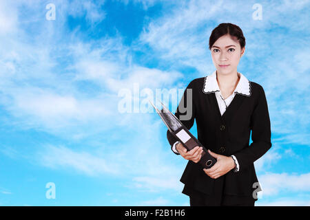 Business Woman holding documents dossier avec le fond de ciel Banque D'Images