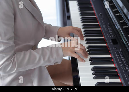 Mains d'une jeune femme jouant du piano Banque D'Images