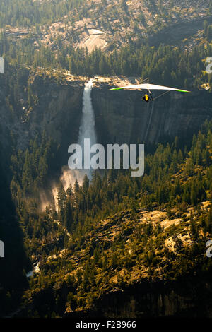 Planeur s'élève très haut au-dessus des chutes d'eau et forêt dans le Parc National de Yosemite, aux États-Unis. Banque D'Images