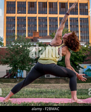 Attractive young woman practicing yoga dans le parc (angle de côté) Banque D'Images