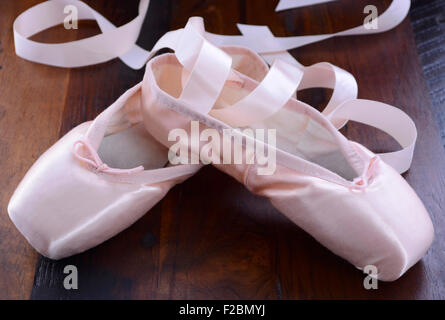 Pointe chaussures de ballet sur fond de bois sombre. Banque D'Images