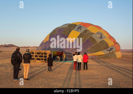 La préparation du ballon à air chaud pour le décollage, au lever du soleil, le désert de Namib, Kulala Wilderness Reserve, Namibie Banque D'Images