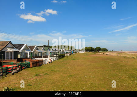 Une rangée de chalets de vacances en bois blanc avec des piquets de clôtures vers Dunster Beach.. Somerset, Angleterre, Royaume-Uni Banque D'Images