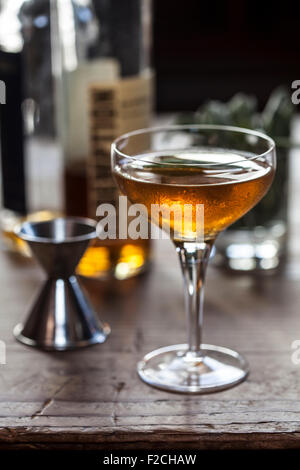 Cocktail orange réfrigérés en verre a pied sur table en bois rustique Banque D'Images