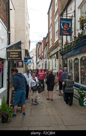 Consommateurs et aux touristes dans Sandgate, une rue étroite à Whitby, Yorkshire, Angleterre, Royaume-Uni Banque D'Images