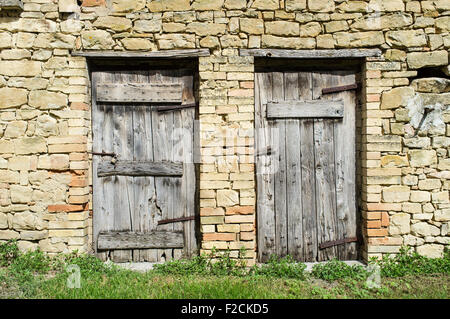 Ancienne grange en pierre dans le Marches Italie avec deux portes en bois patiné Banque D'Images