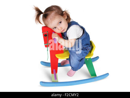 Funny enfant réfléchie rêves sur cheval jouet, isolated on white Banque D'Images