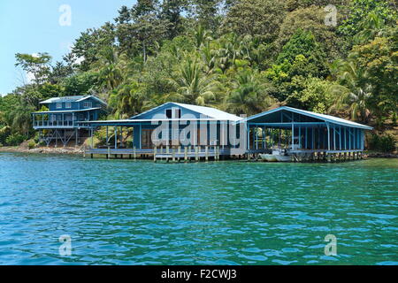 Caribbean home et maison bateau sur l'eau avec une végétation tropicale sur la côte, Panama, Amérique Centrale Banque D'Images