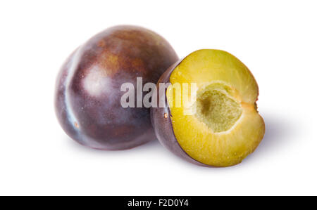 Ensemble et la moitié des prunes violettes près isolé sur fond blanc Banque D'Images