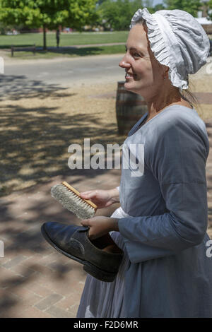 Acteur période habillé en maid smiling, une chaussure à nettoyer la ville coloniale de Williamsburg living-history museum Virginia Banque D'Images