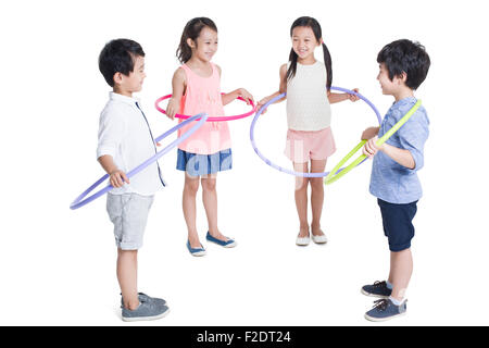 Des enfants heureux de tourner des cerceaux en plastique Banque D'Images