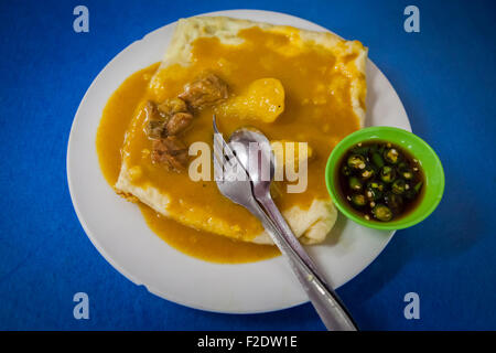 Un mélange de murtabak (pain farci poêlé) avec sauce, viande et condiment dans un restaurant de Palembang, Sumatra Sud, Indonésie. Banque D'Images