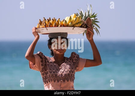 Femme autochtone avec un bol de bananes sur la tête et Thanaka coller sur son visage, la vente de bananes sur la plage de Ngapali Beach Banque D'Images