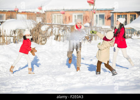 Jeune famille d'avoir une bataille de boules de neige dans la neige