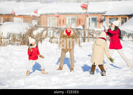 Jeune famille d'avoir une bataille de boules de neige dans la neige