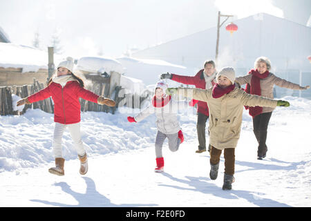 Happy Family running in the snow Banque D'Images