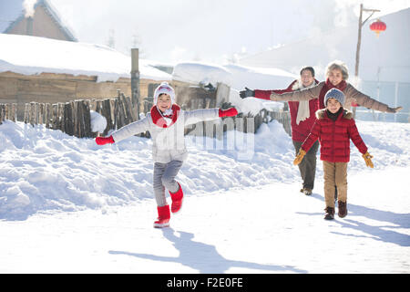 Happy Family running in the snow Banque D'Images