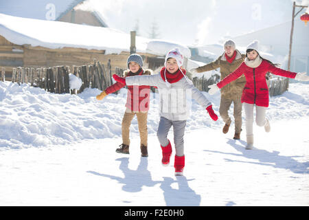 Happy Family running in the snow Banque D'Images