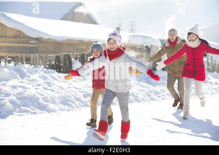 Happy Family running in the snow Banque D'Images