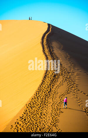 Les gens à monter la Dune 45 dans le désert de Namibie, l'Afrique Banque D'Images