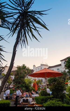 Les gens de manger en plein air dans le style carré orange, vieille ville de Marbella, Espagne. Banque D'Images