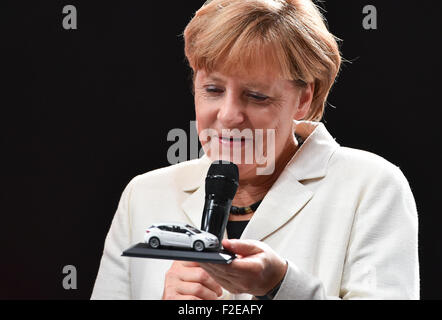 Francfort, Allemagne. 17 Sep, 2015. La chancelière allemande, Angela Merkel (CDU) est titulaire d'un modèle miniature de la nouvelle Astra voiture au stand de constructeur automobile Opel lors de l'ouverture du Salon International de l'automobile IAA de Francfort/Main, Allemagne, 17 septembre 2015. Du 17 au 27 septembre les fabricants du monde entier montrer les innovations de l'industrie automobile. Banque D'Images