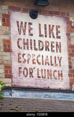 Nous aimons les enfants en particulier pour le panneau de déjeuner sur le côté du bâtiment de brique à Brewery Square, Dorchester Sud, Dorset UK en juin Banque D'Images