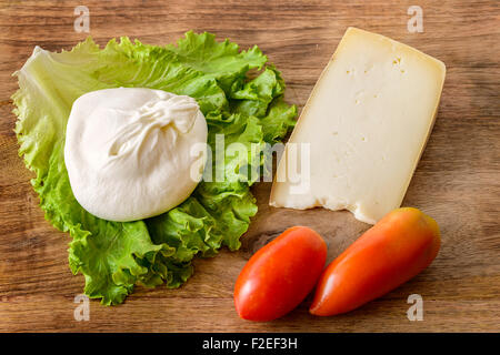 Burrata, du fromage, des tomates et de la salade sur la table en bois Banque D'Images