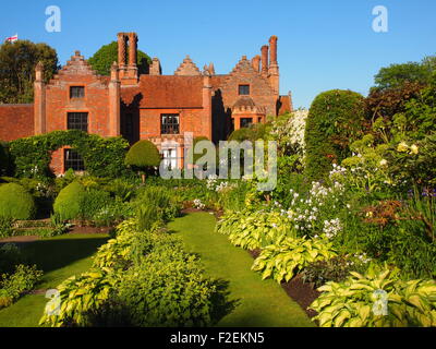 Chenies Manor, Buckinghamshire au début de juin, montrant une croissance verte dans le jardin en contrebas au manoir avec ciel bleu Banque D'Images