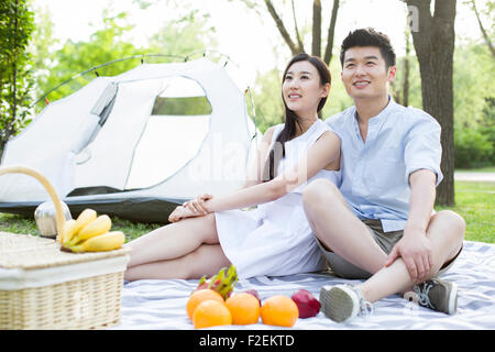 Happy young couple having picnic sur l'herbe Banque D'Images