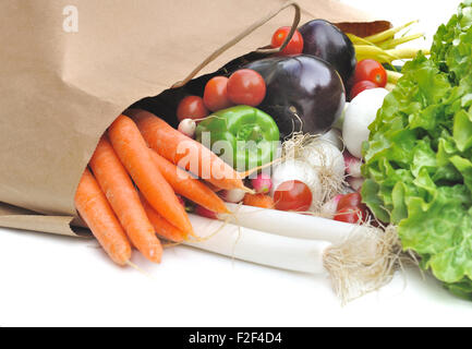 Légumes frais sortant d'un sac en papier d'épicerie sur fond blanc Banque D'Images