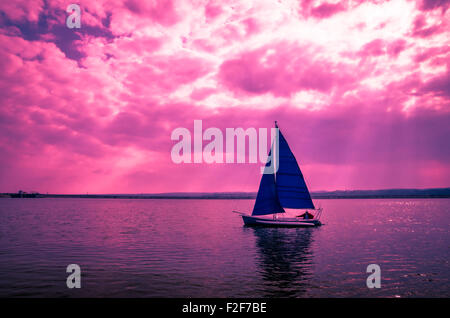 Voilier au coucher du soleil. Pêcheur au soir de la pêche dans le temps avec son bateau. Banque D'Images