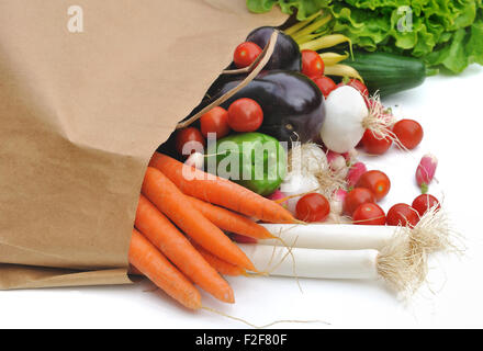 Légumes frais sortant d'un sac en papier d'épicerie sur fond blanc Banque D'Images