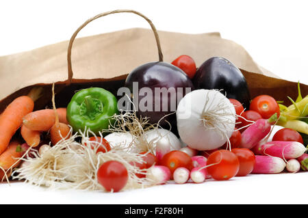 Légumes frais sortant d'un sac en papier d'épicerie sur fond blanc Banque D'Images