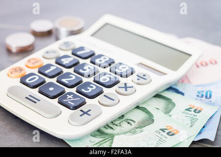 Calculatrice avec de l'argent sur fond gris, stock photo Banque D'Images