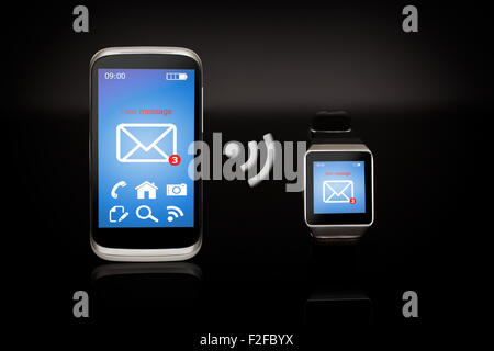 Smart watch internet moderne et smartphone sur fond noir. Banque D'Images
