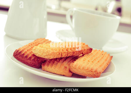 Libre d'une plaque avec une pile de biscuits faits maison et une tasse de café ou de thé sur la table de cuisine Banque D'Images