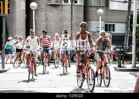 Les touristes riding bikes dans Villa Olimpica, Barcelone Banque D'Images