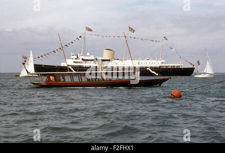 AJAXNETPHOTO. COWES, ÎLE DE WIGHT, Angleterre. - ROYAL YACHT - le yacht royal Britannia habillés dans l'ensemble ANCRÉ À LA MECQUE DU YACHTING AU COURS DE LA SEMAINE DE COWES YACHT À VAPEUR AVEC LE BANSHEE EN TRANSMETTANT L'FOREGORUND. photo:JONATHAN EASTLAND/AJAX REF:010561 Banque D'Images