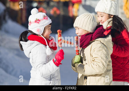 Heureux les enfants mangeant haws confits Banque D'Images