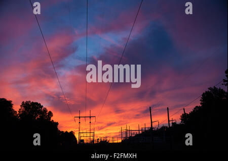 Les lignes de transmission convergent pour une sous-station électrique sous un ciel de coucher du soleil à Snellville (métro) Atlanta, Georgia, USA. Banque D'Images