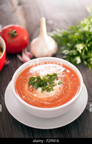 Délicieuse soupe de tomate avec des épices aromatiques sur une table en bois. Studio shot Banque D'Images