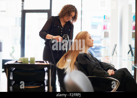 Coiffure cheveux longs du client de séchage dans le salon Banque D'Images