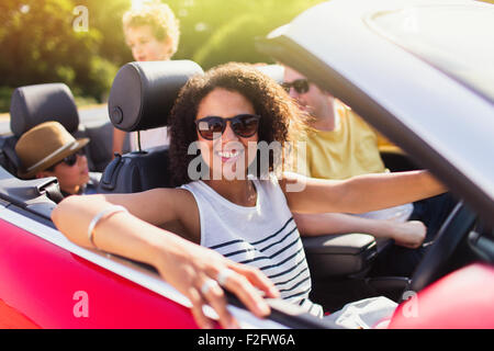Portrait femme enthousiaste driving convertible en famille Banque D'Images