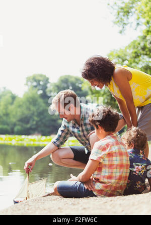 Family Playing with toy voilier à Lakeside Banque D'Images